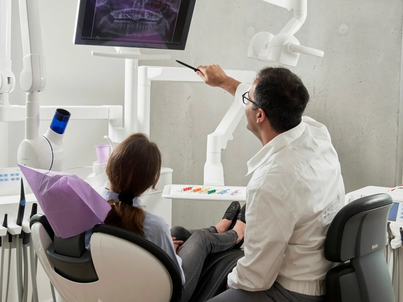 Dentist reviewing treatment options with a patient in a modern dental clinic